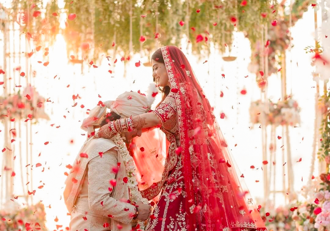 Bride and groom beneath a floral mandap at Excel Hotels & Resorts